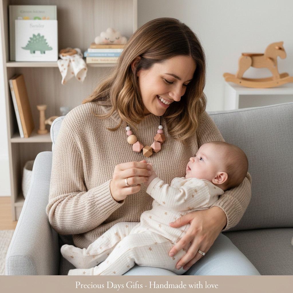 Precious Days Gifts chunky neutral silicone and wood teething necklace worn by a mother holding her baby.