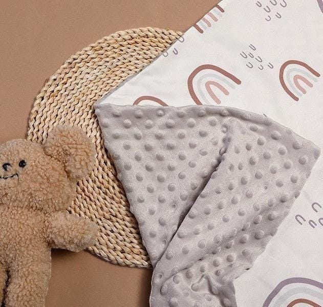 Precious Days Gifts soft grey minky dot fleece baby blanket with a rainbow print blanket and a plush toy.