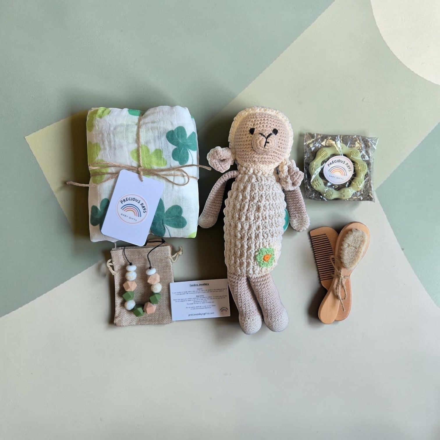 Precious Days Gifts Signature Belfast Box with shamrock muslin, crochet sheep rattle, teething ring, and baby brush.