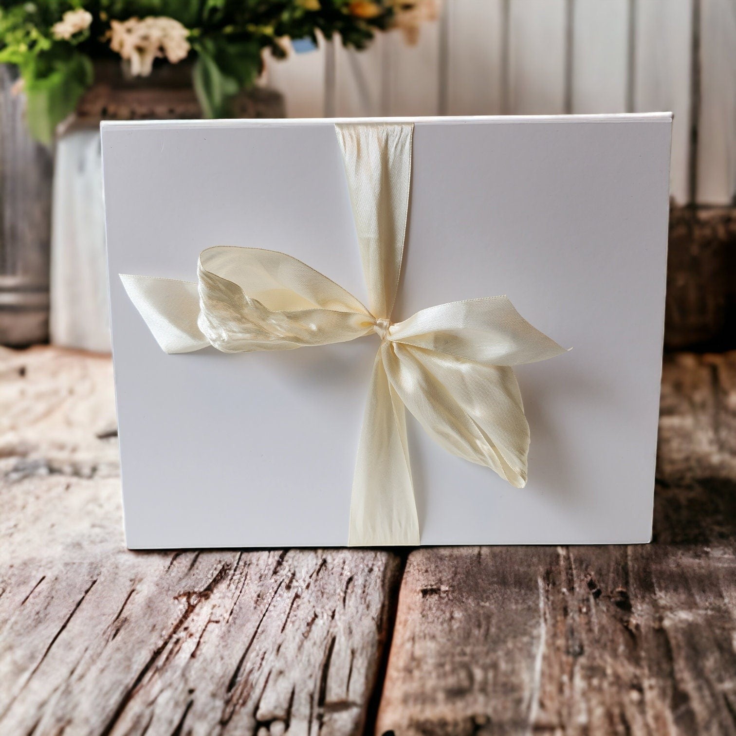 Precious Days Gifts Large New Baby Gift Box with a pig rattle, muslin, and soap. White box with cream ribbon.