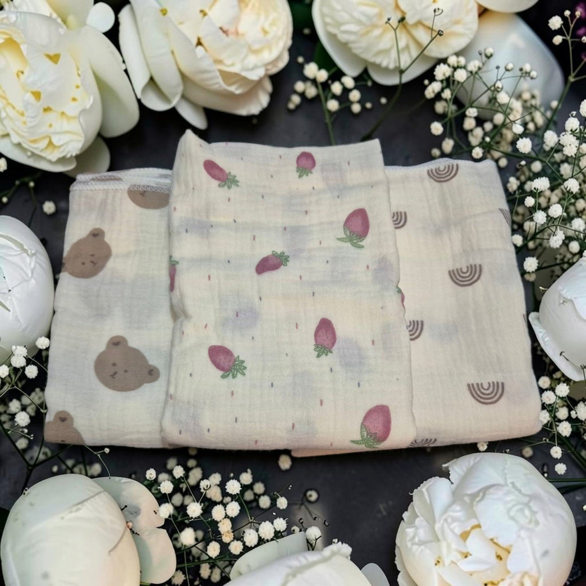 Precious Days Gifts trio of soft cotton baby muslin cloths featuring bear, strawberry, and rainbow patterns.