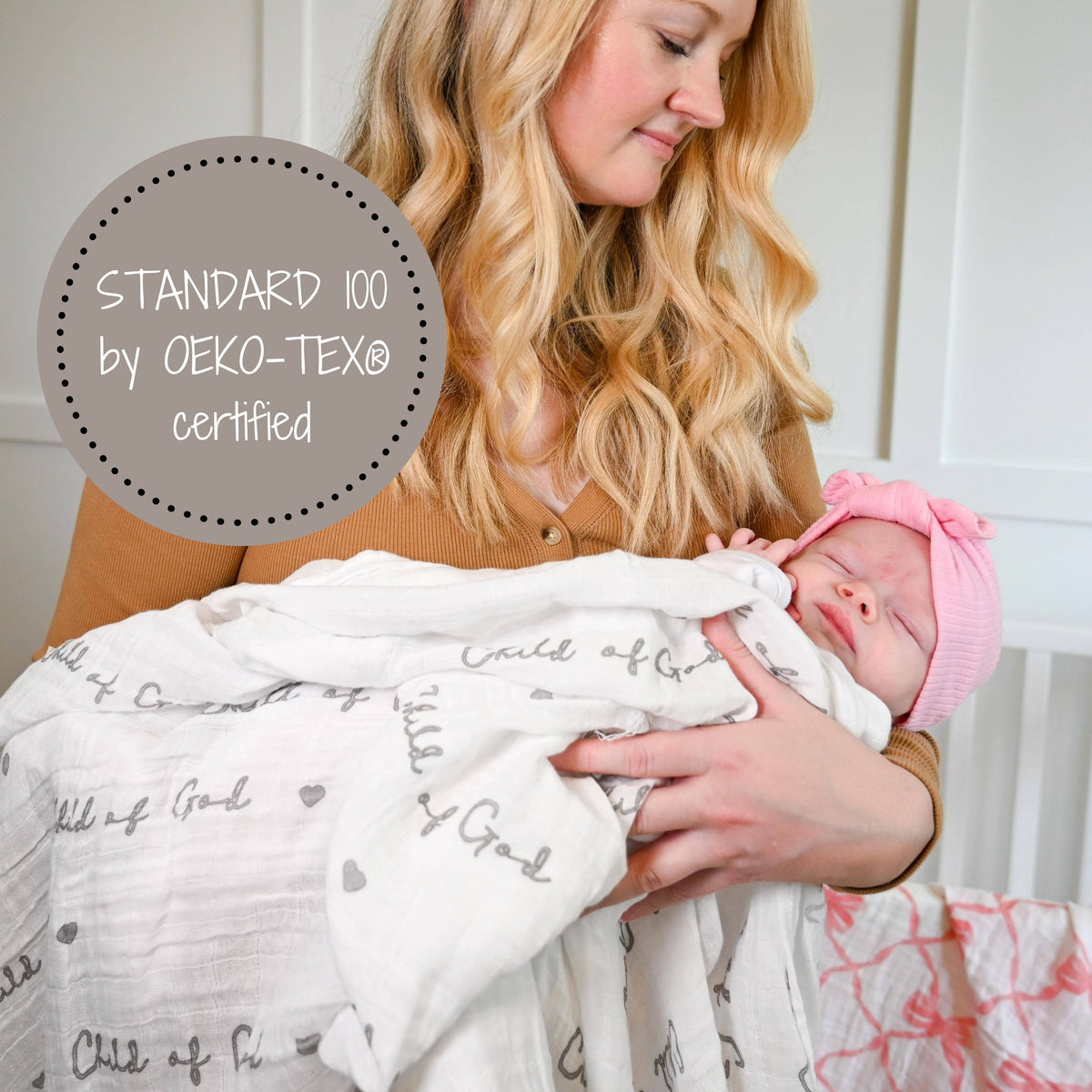 Precious Days Gifts white cotton muslin swaddle blanket with Child of God print held by a mother with her newborn