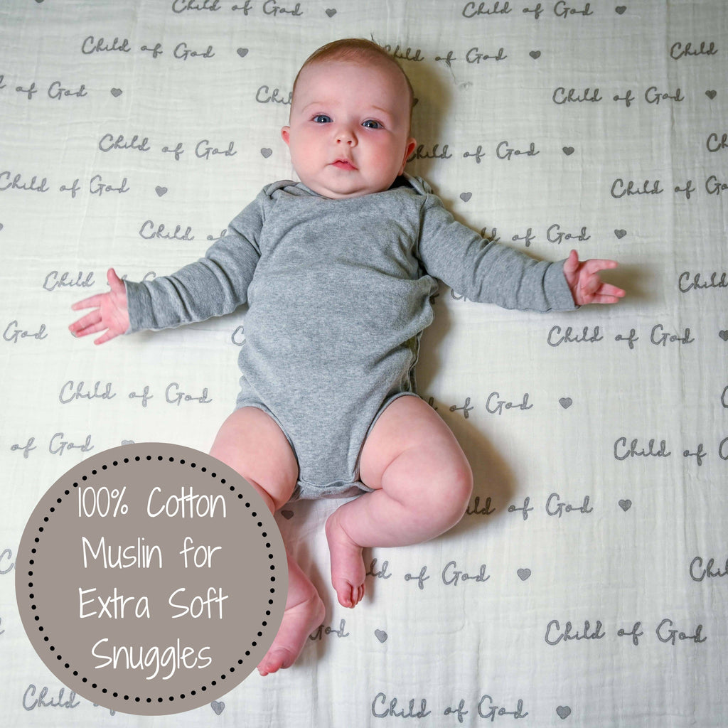 Precious Days Gifts baby lying on a soft white muslin swaddle blanket with Child of God text and heart pattern