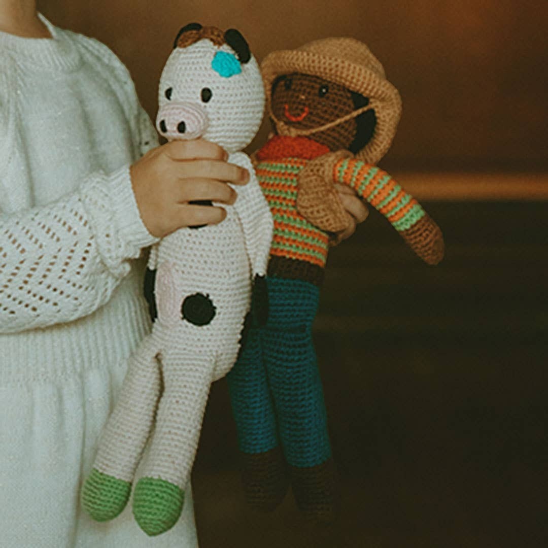 Precious Days Gifts handmade organic cotton plush cow toy with embroidered details and green hooves.