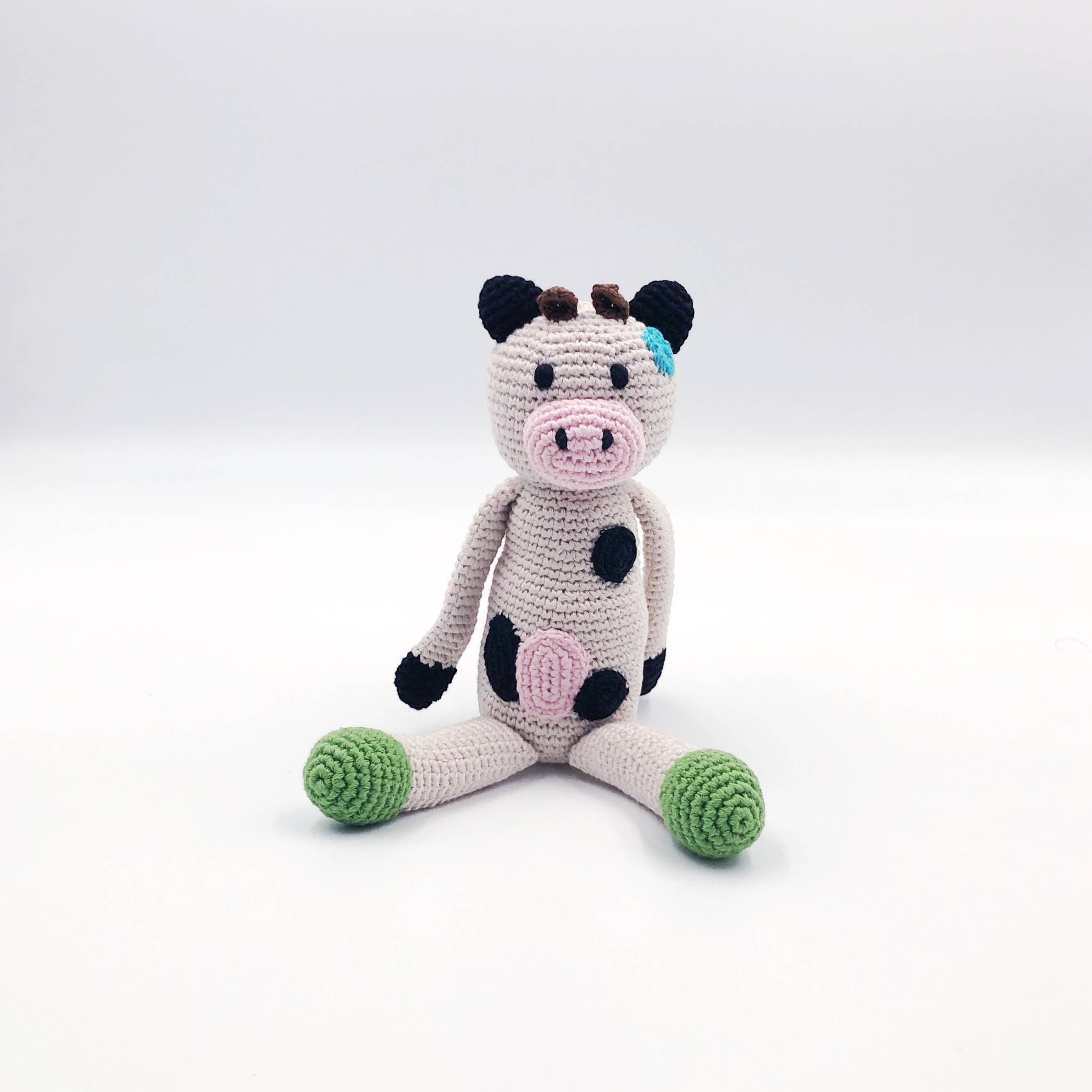 Precious Days Gifts handmade organic cotton plush cow toy with pink nose, black spots, and green feet.