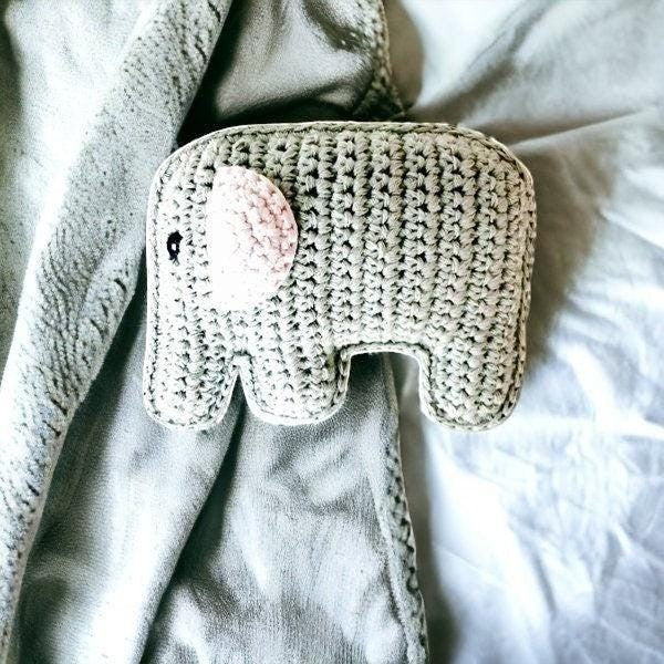 Precious Days Gifts grey crochet elephant rattle with pink ear detail on a soft grey blanket.