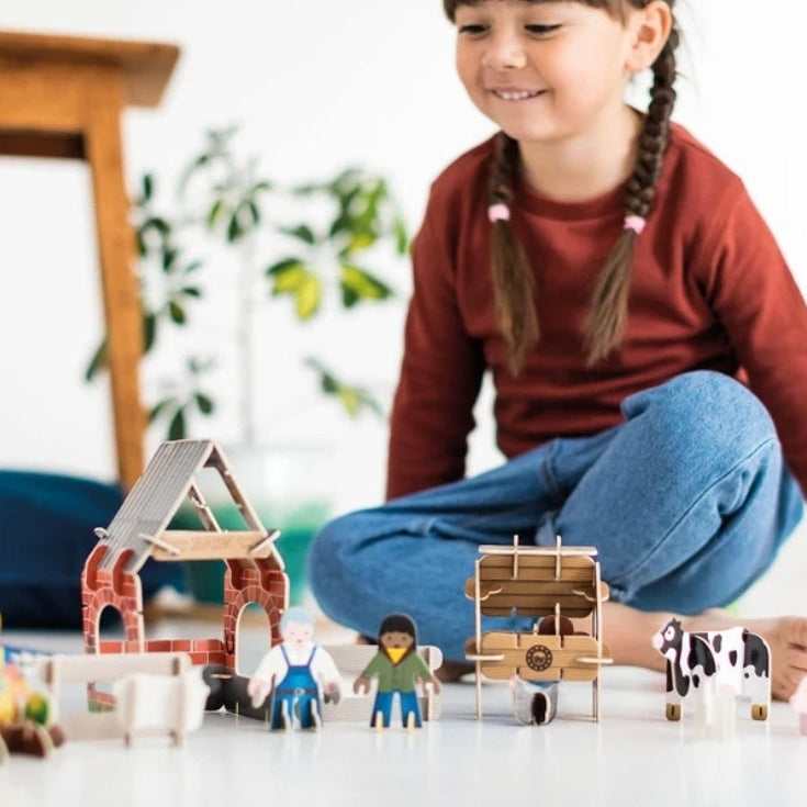Precious Days Gifts Play Press Toys Farmyard Set featuring a young girl playing with sustainable cardboard farm pieces