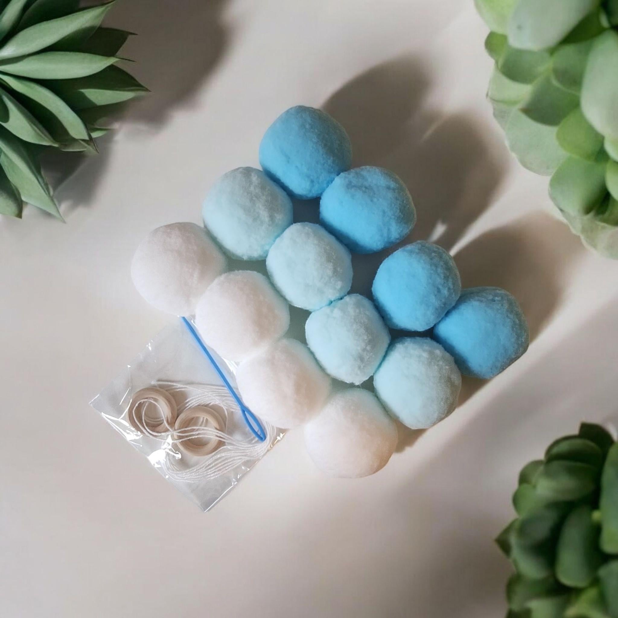 Precious Days Gifts Felt Ball Garland Craft Kit with white and blue pom poms, string, and wooden rings.