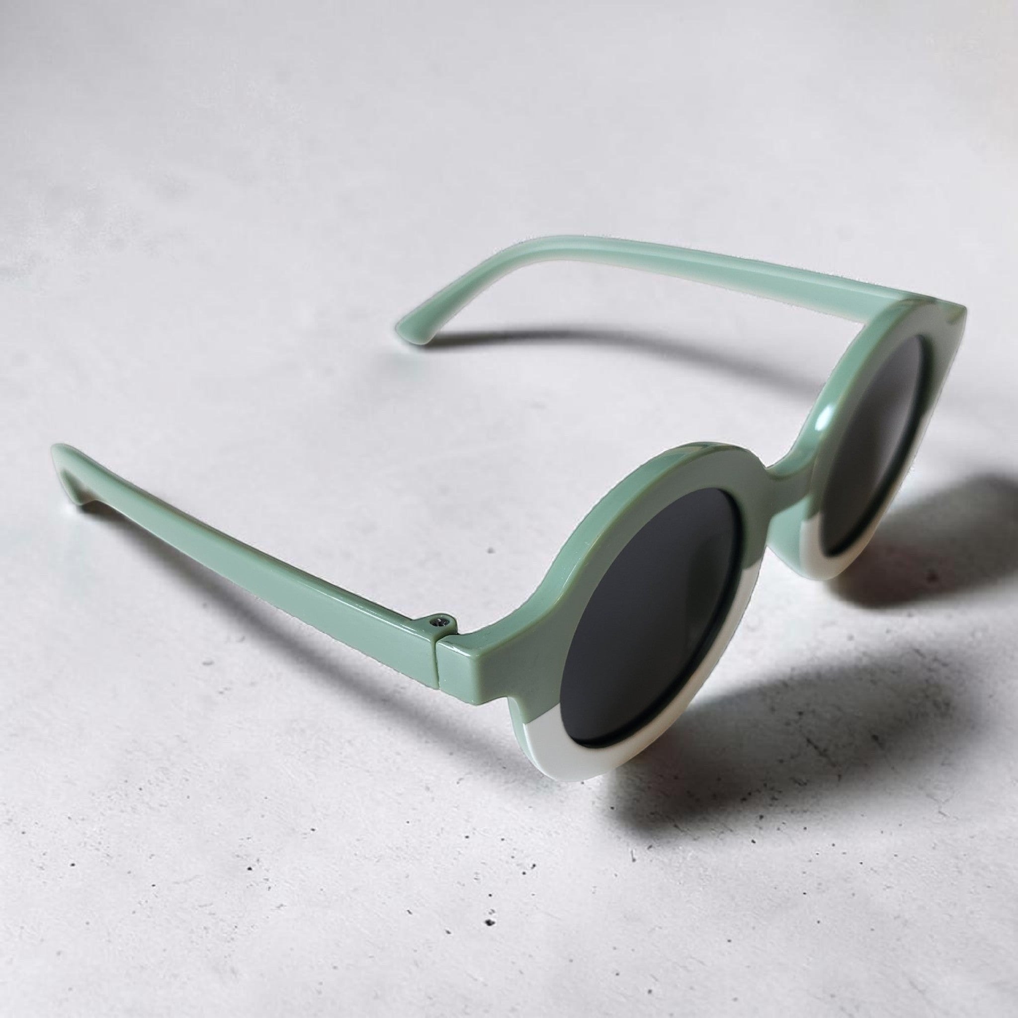 Precious Days Gifts two-tone sage green and white round frame sunglasses for kids with dark lenses.