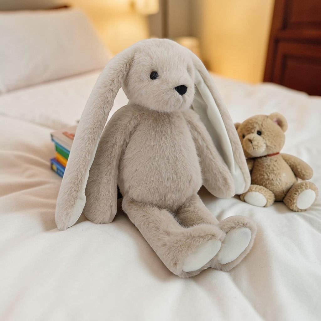 Precious Days Gifts luxury large super soft beige bunny toy sitting on a white bed next to a small teddy bear
