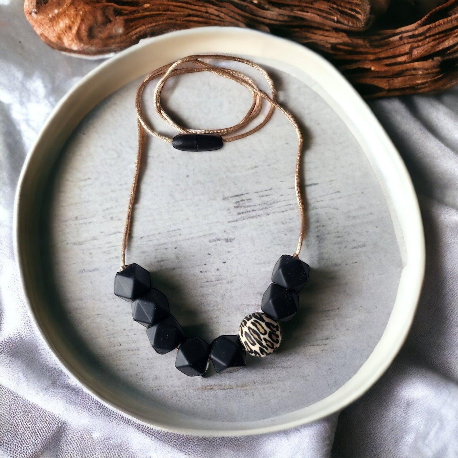 Precious Days Gifts handmade silicone teething necklace with black geometric beads and a leopard print accent bead.