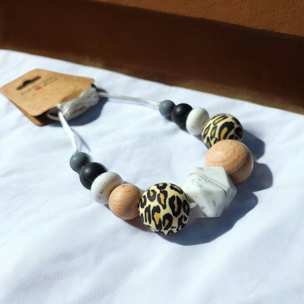Precious Days Gifts handmade silicone teething necklace with leopard print, wood, and marble effect beads.