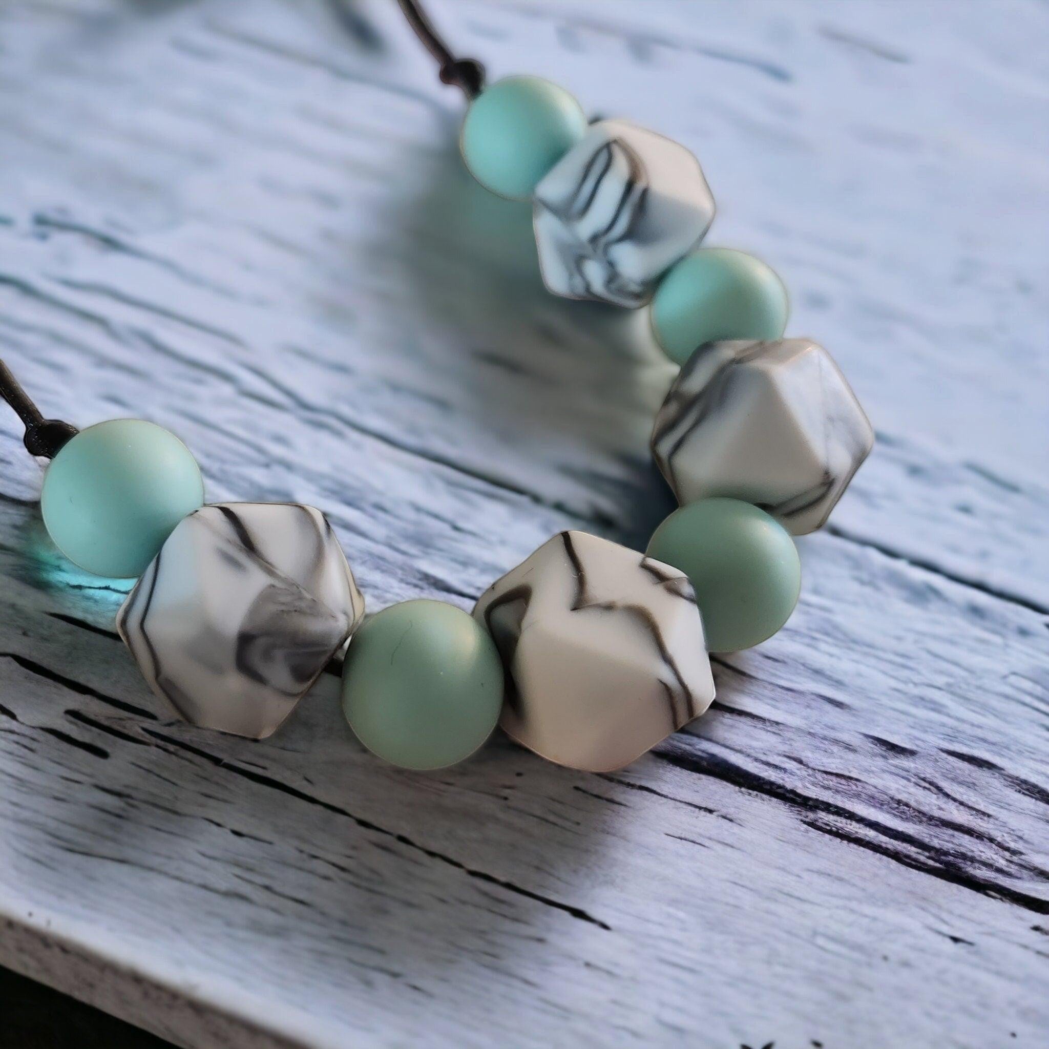 Precious Days Gifts mint marble silicone teething necklace with geometric and round beads.