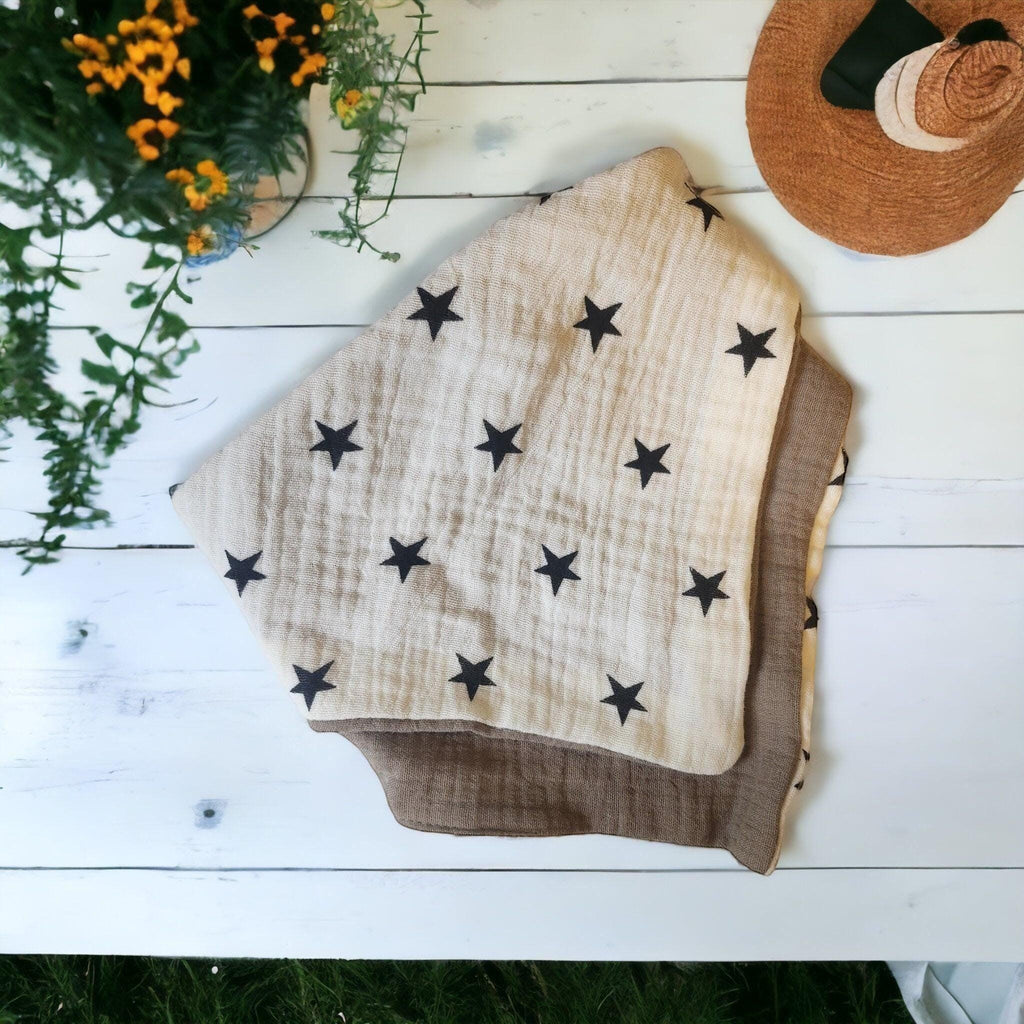 Precious Days Gifts soft muslin baby bibs with black stars on a beige background. Highly absorbent and breathable cotton.