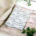 Precious Days Gifts 100% cotton muslin baby swaddle blanket with You Are My Sunshine print in black text on white.