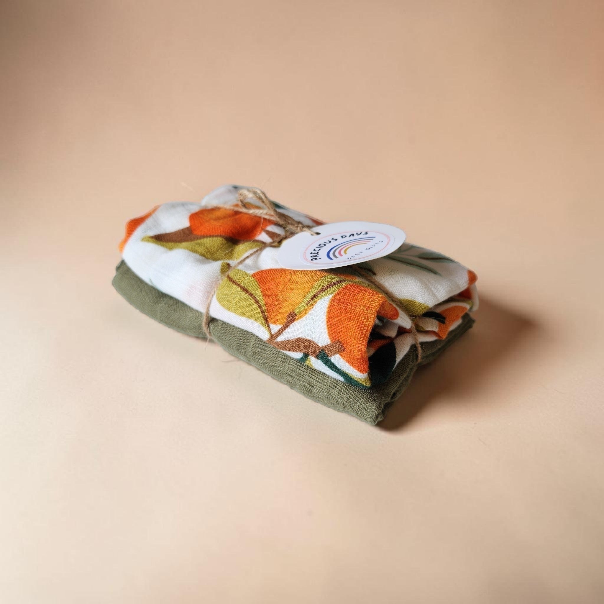 Precious Days Gifts Muslin Duo Gift Set with orange floral print and solid green swaddles, 60x60cm.