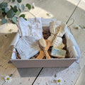 Precious Days Gifts new baby essentials box with clouds onesie, hat, natural soap, muslin cloths, and hairbrush set.
