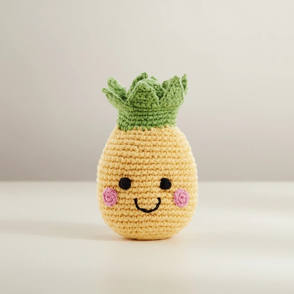 Precious Days Gifts yellow crocheted pineapple rattle with green leaves, embroidered face, and pink cheeks.
