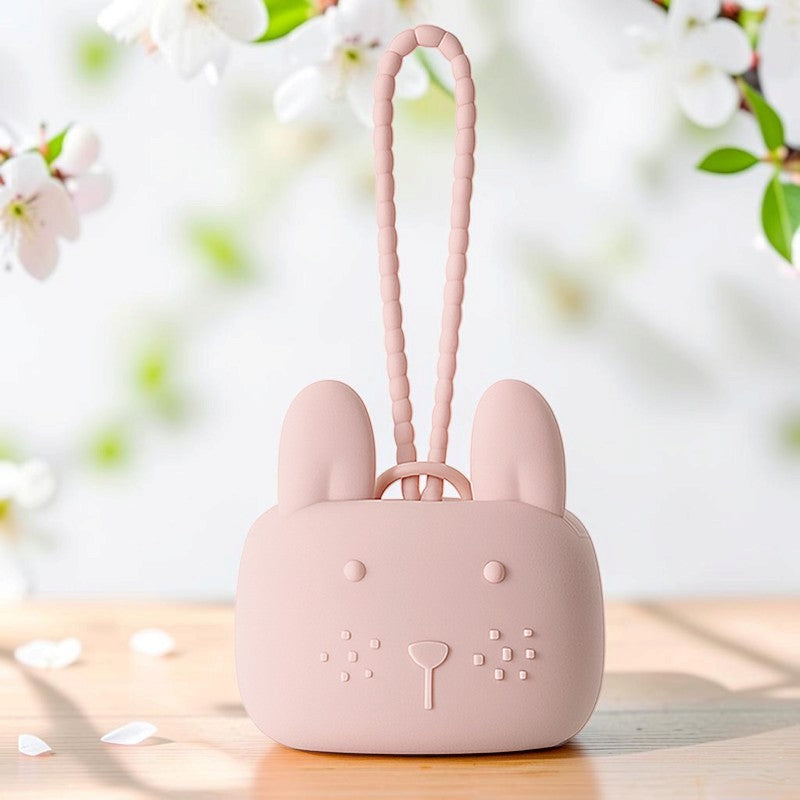 Precious Days Gifts pink silicone bunny storage pouch with a textured wrist strap on a wooden surface.