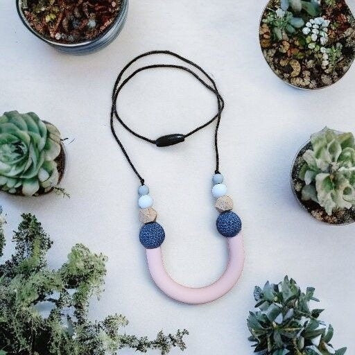 Precious Days Gifts pink silicone U-shape teething necklace with blue textured beads and wood accents
