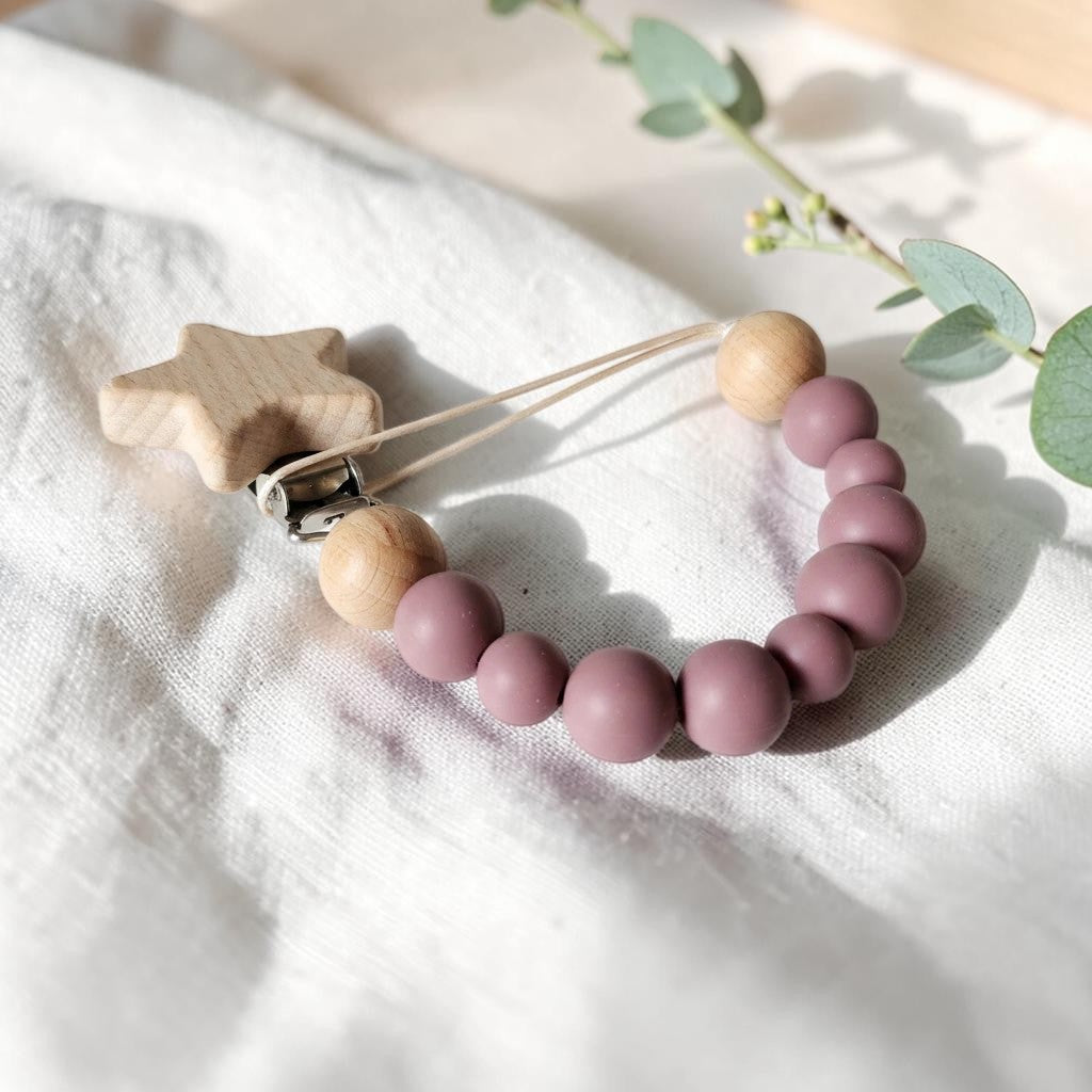 Precious Days Gifts pink silicone and wooden star dummy clip on a white linen background