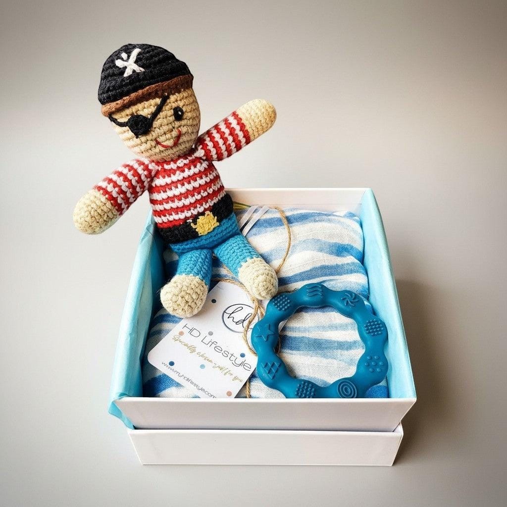 Precious Days Gifts pirate baby gift box with crochet pirate toy, blue striped muslin, and teal silicone teether.