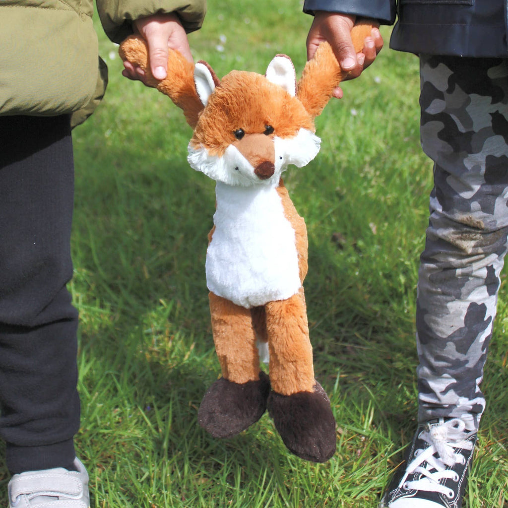 Precious Days Gifts soft plush fox toy held by two children outdoors on a grassy field.