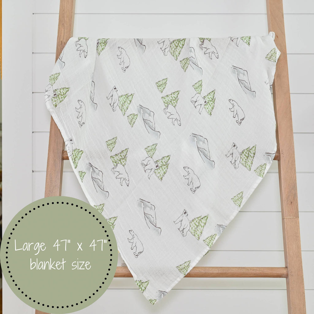 Precious Days Gifts muslin swaddle blanket featuring a polar bear and pine tree print on a white cotton fabric.