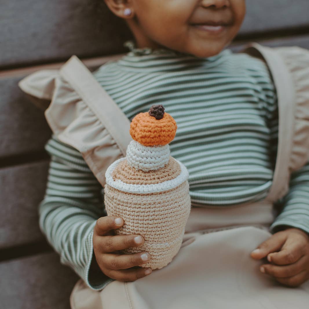 Precious Days Gifts handmade crochet pumpkin spice latte rattle held by a child in a striped shirt