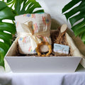 Precious Days Gifts Over the Rainbow baby gift box with 6-layer cotton muslin blanket, teether, brush, comb, and soap.