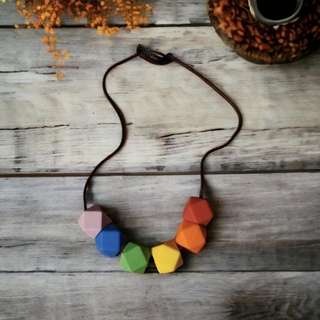 Precious Days Gifts rainbow silicone teething necklace with geometric beads for babies.