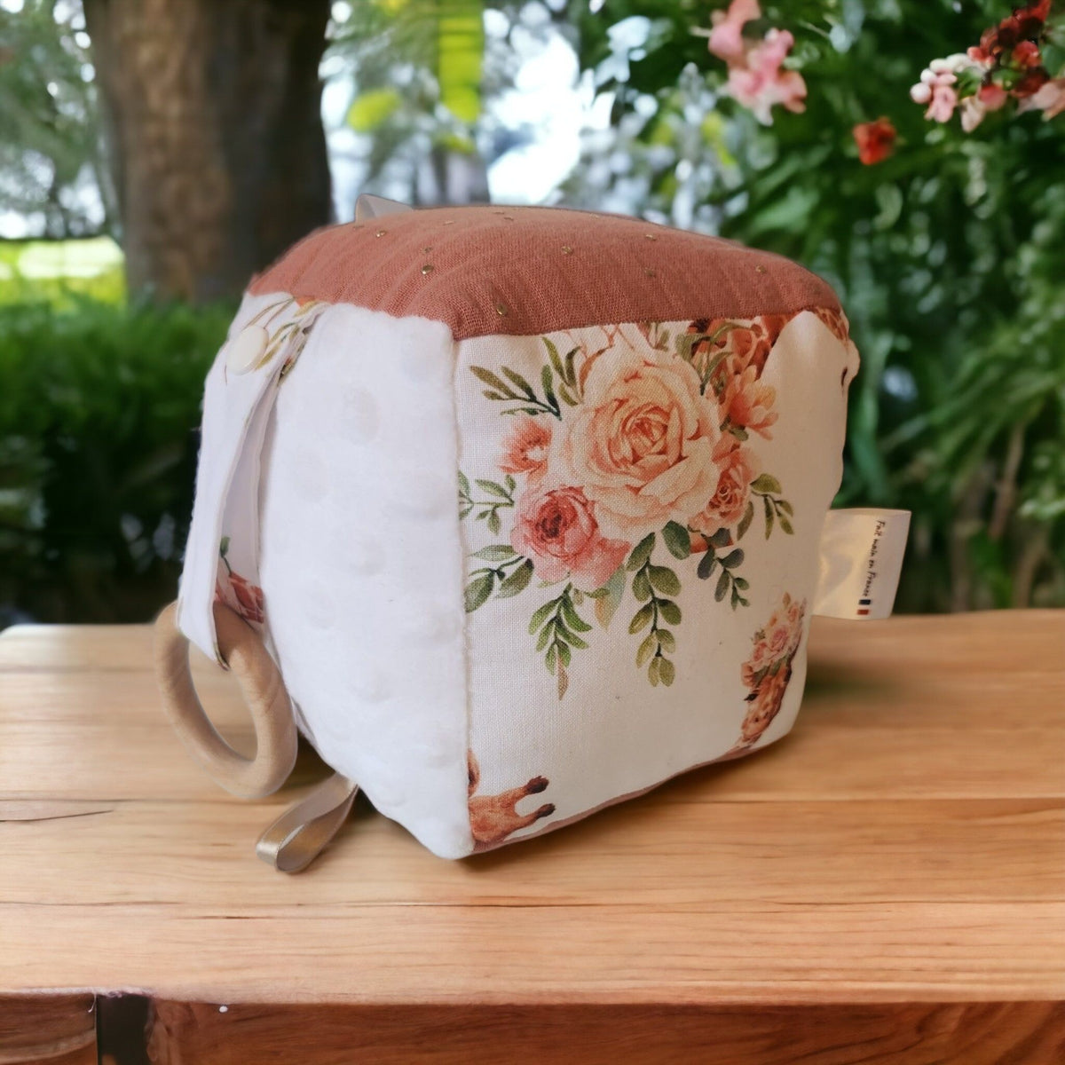 Precious Days Gifts soft sensory baby activity cube with floral print, white minky fabric, and wooden teething ring.