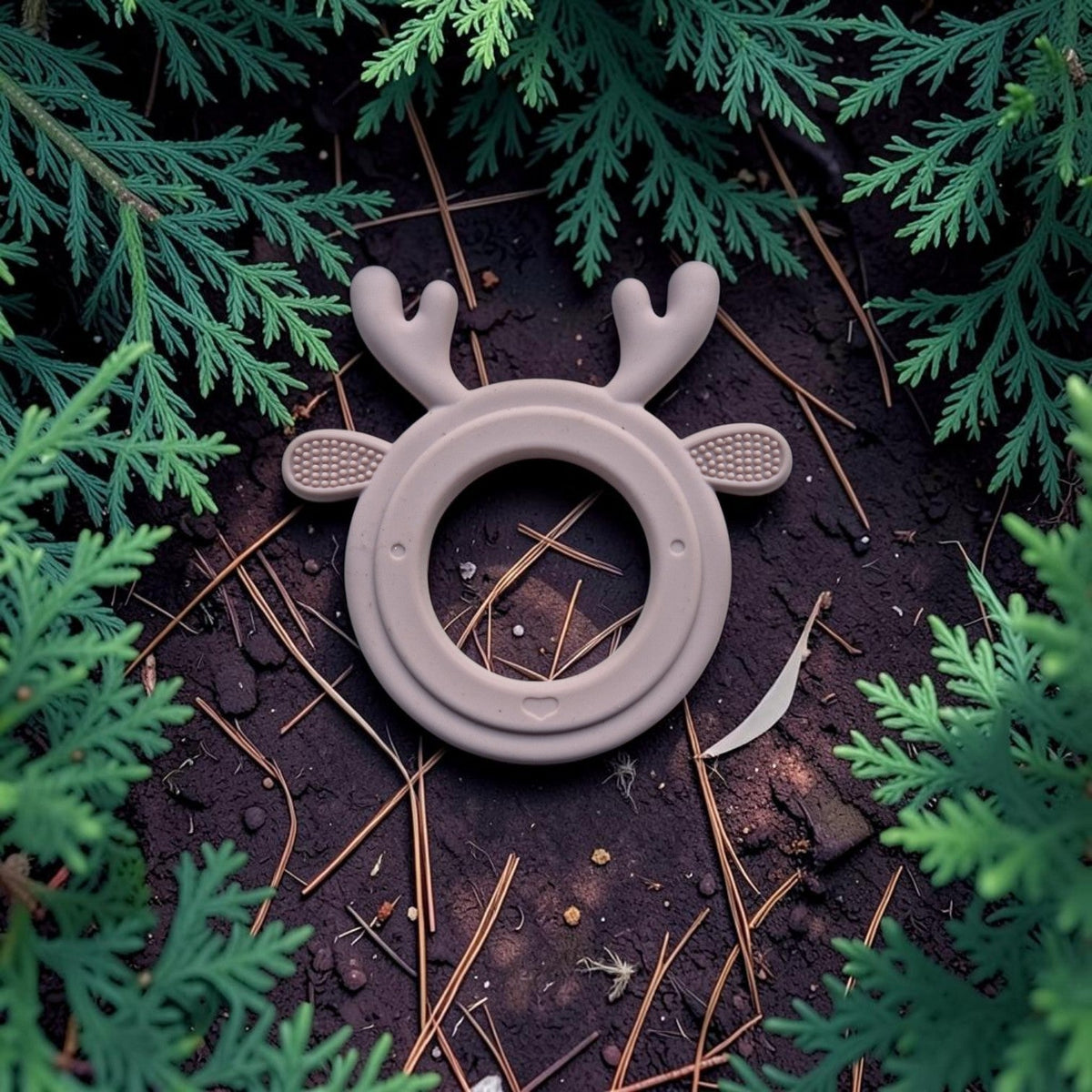 Precious Days Gifts silicone reindeer teether in a neutral beige, featuring textured antlers on a forest floor.