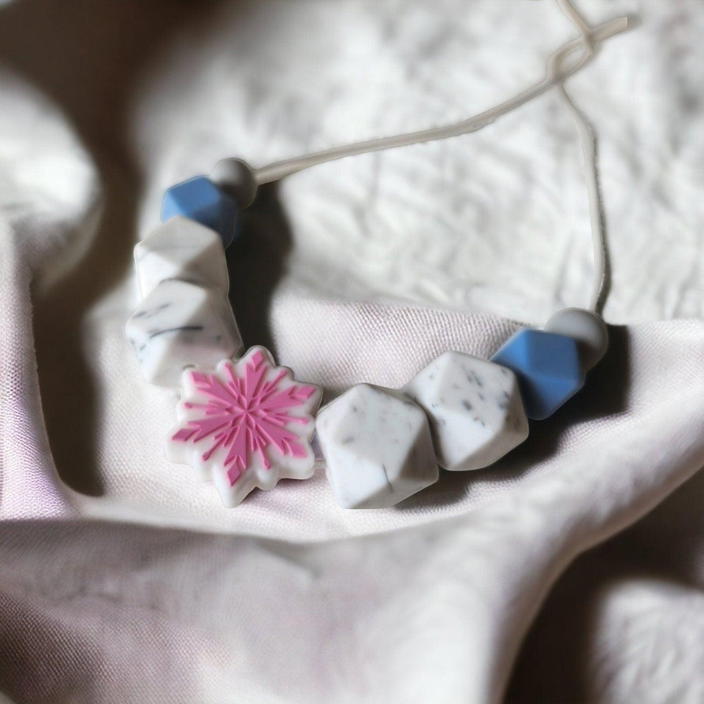 Precious Days Gifts silicone feeding necklace with pink snowflake, grey, blue, and marble-effect beads.