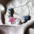 Precious Days Gifts silicone feeding necklace with pink snowflake, grey, blue, and marble-effect beads.