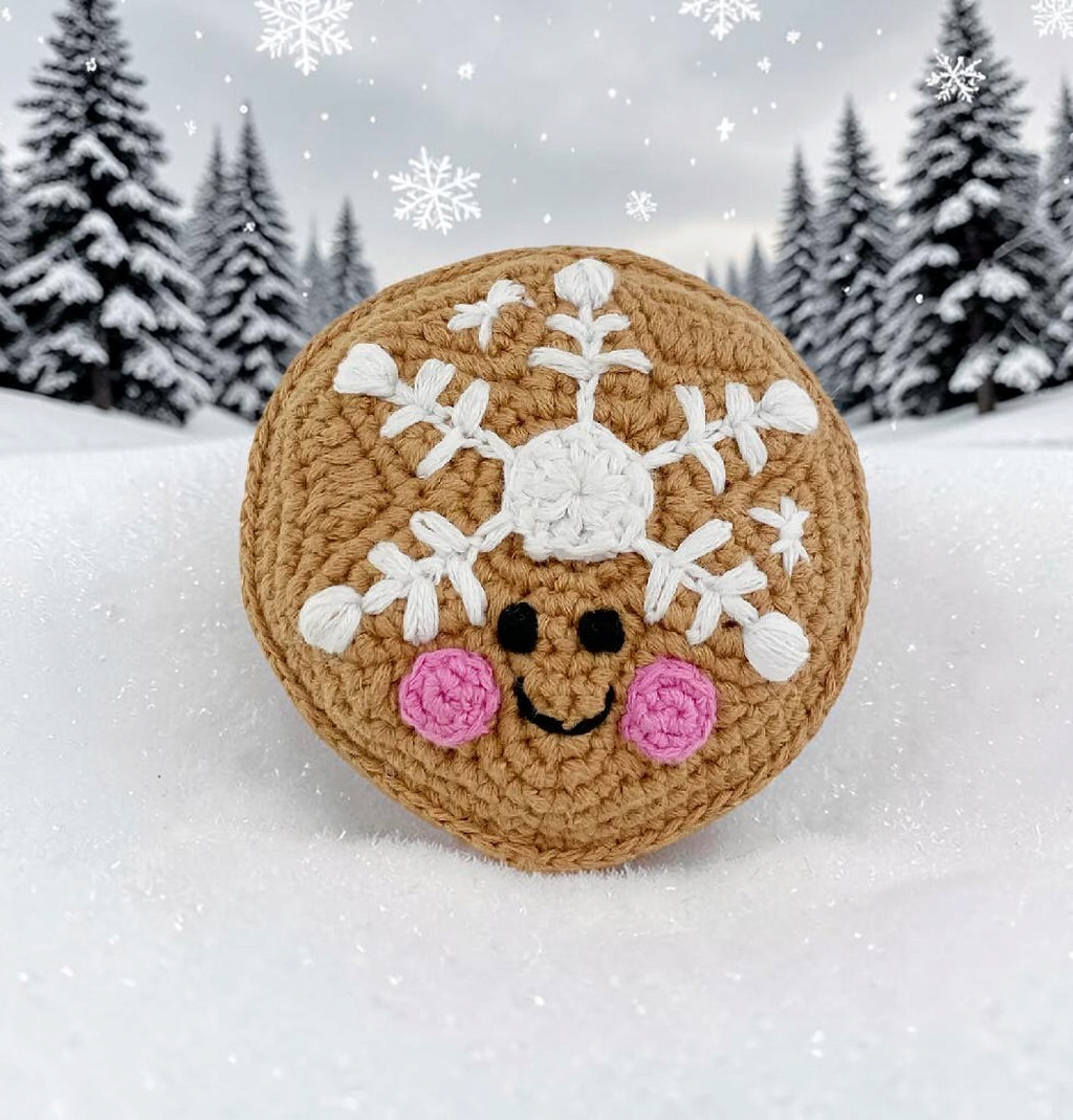 Precious Days Gifts organic cotton sugar cookie rattle with snowflake embroidery and pink cheeks in snowy setting