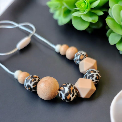 Precious Days Gifts handmade teething necklace with wood, silicone leopard print and geometric beads on a satin cord.