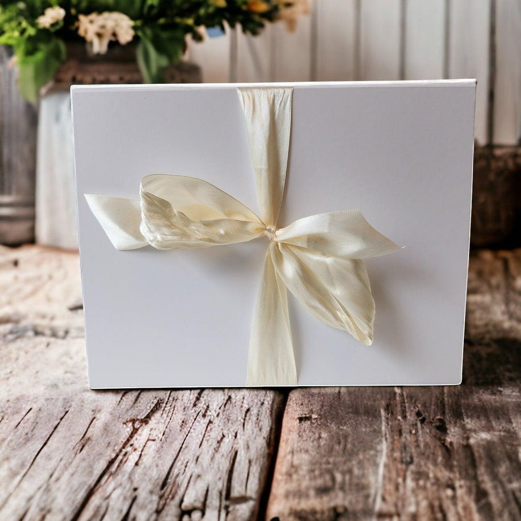 Precious Days Gifts white gift box with a cream ribbon bow, perfect for baby gifts.